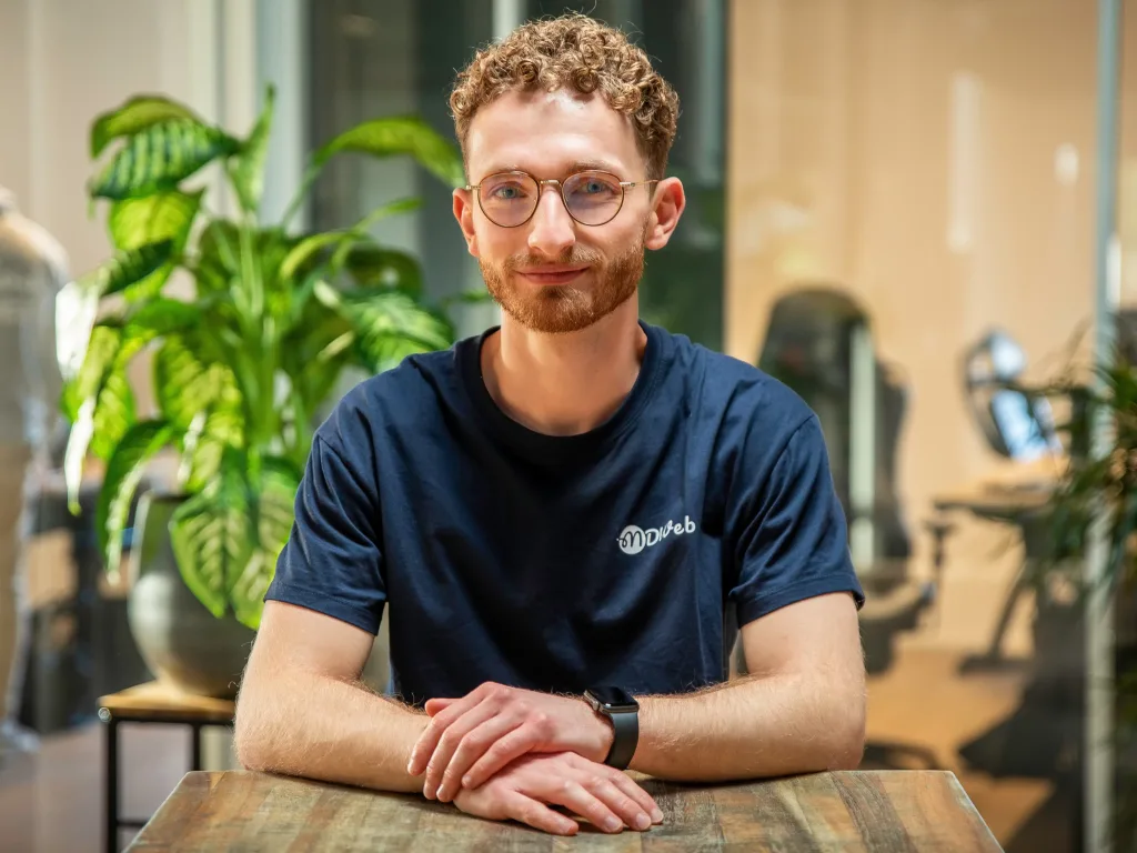 Jeune homme aux lunettes rondes portant un t-shirt MDWeb