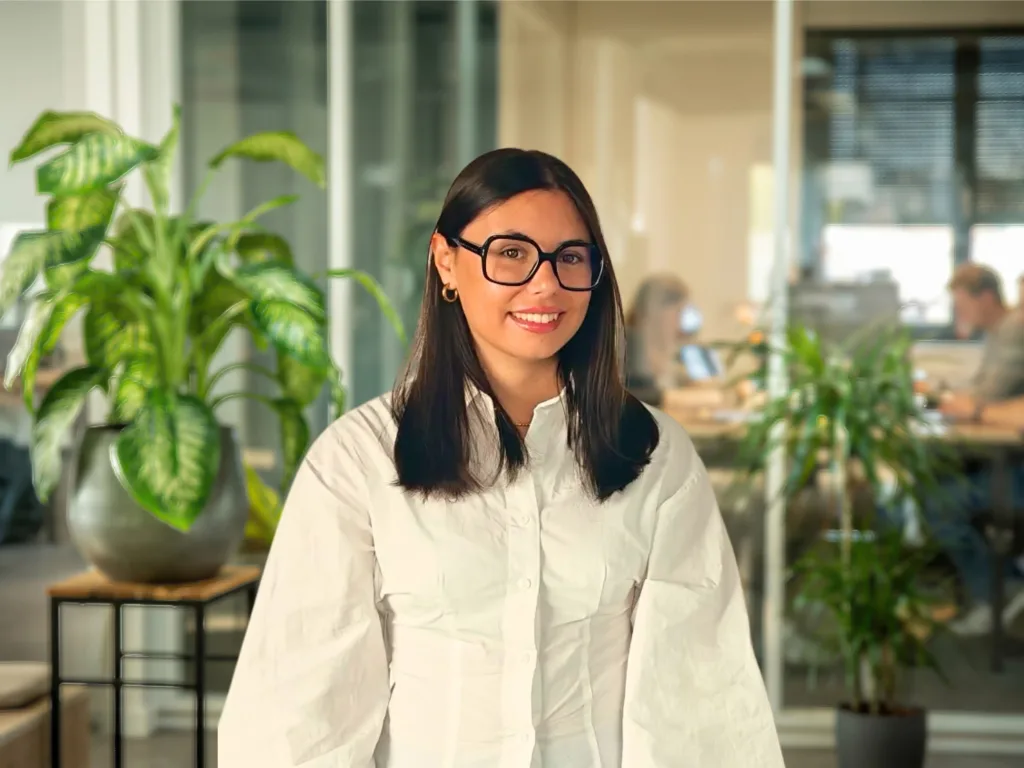 Jeune femme souriante à lunettes dans un bureau moderne